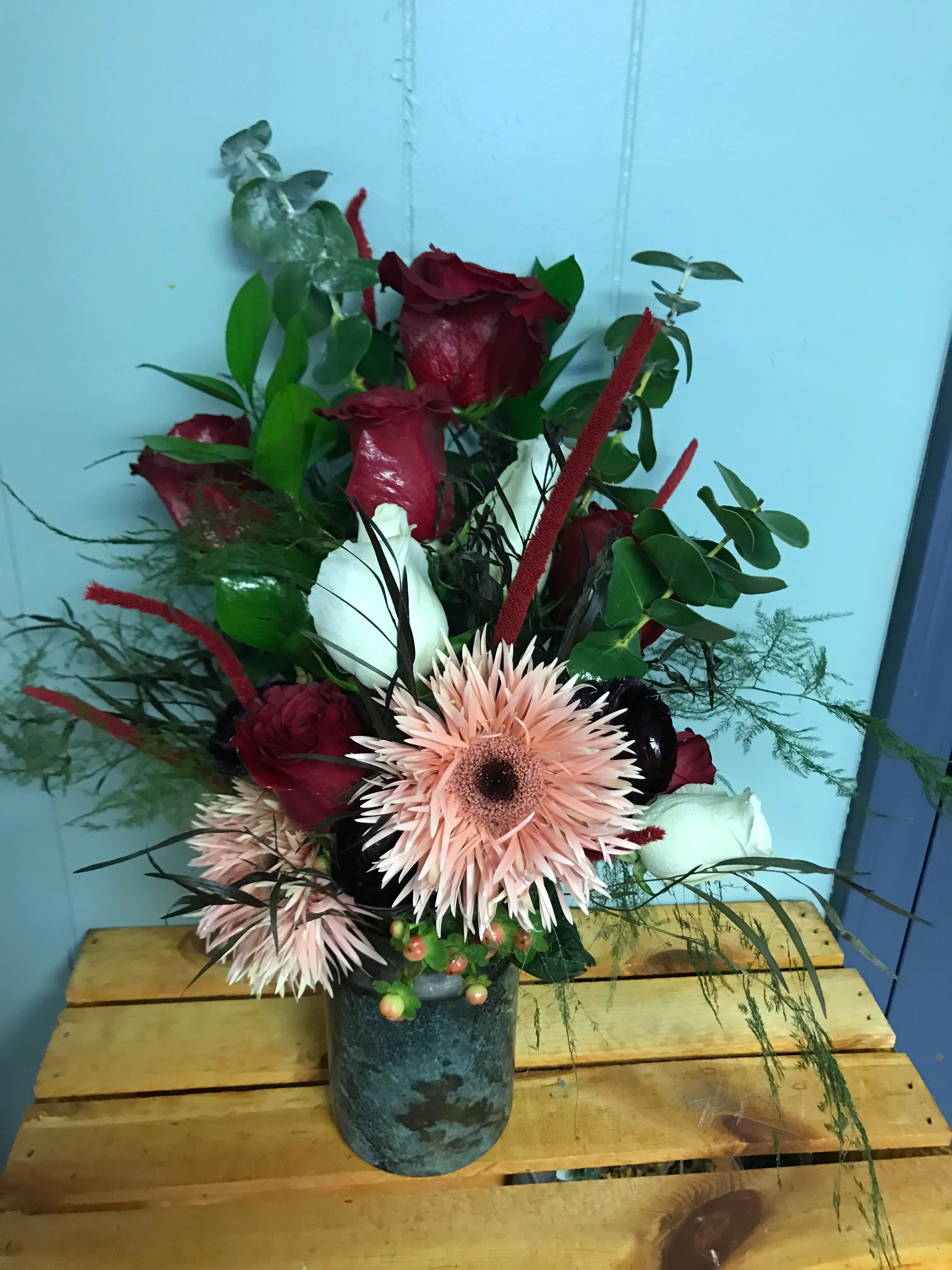 Red roses and peach spider gerbera in a galvanised tin