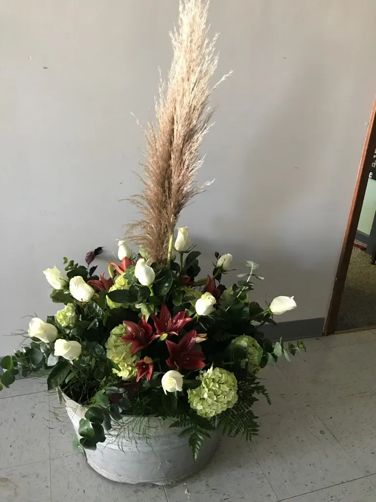 Casket spray in white and burgundy with pampas grass