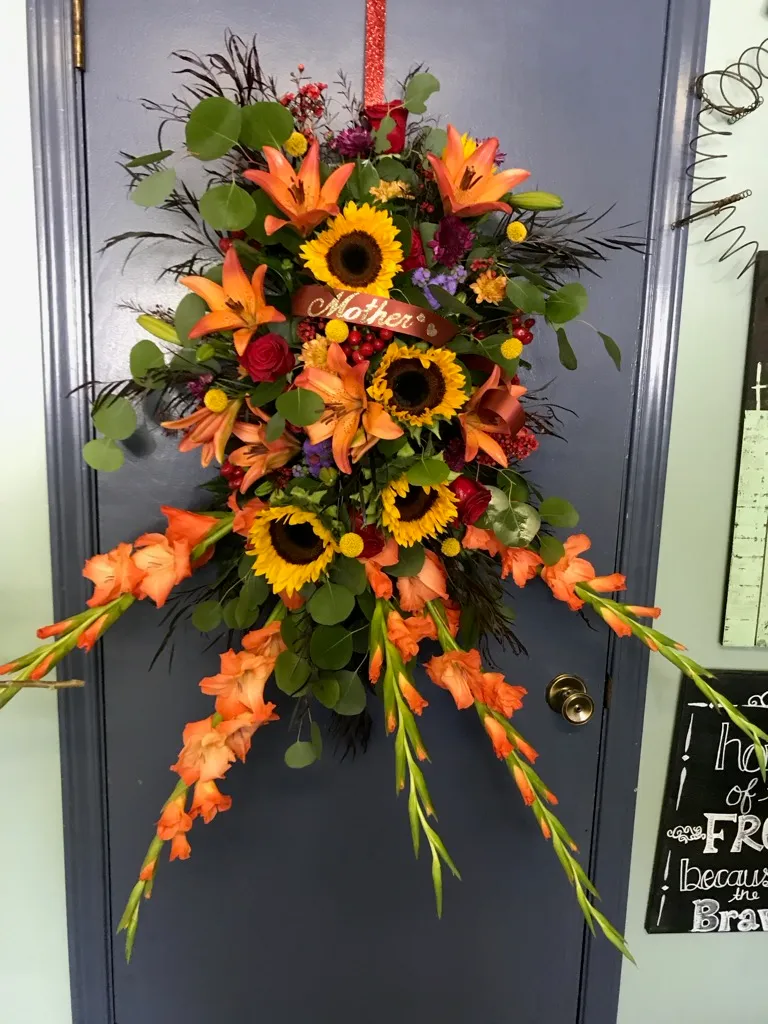 Easel tribute with sunflowers and orange gladiolus