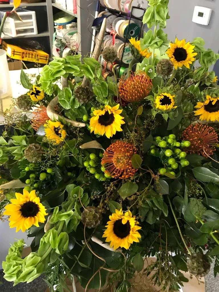 Standing spray with sunflowers, pincushion protea and green hydrangea